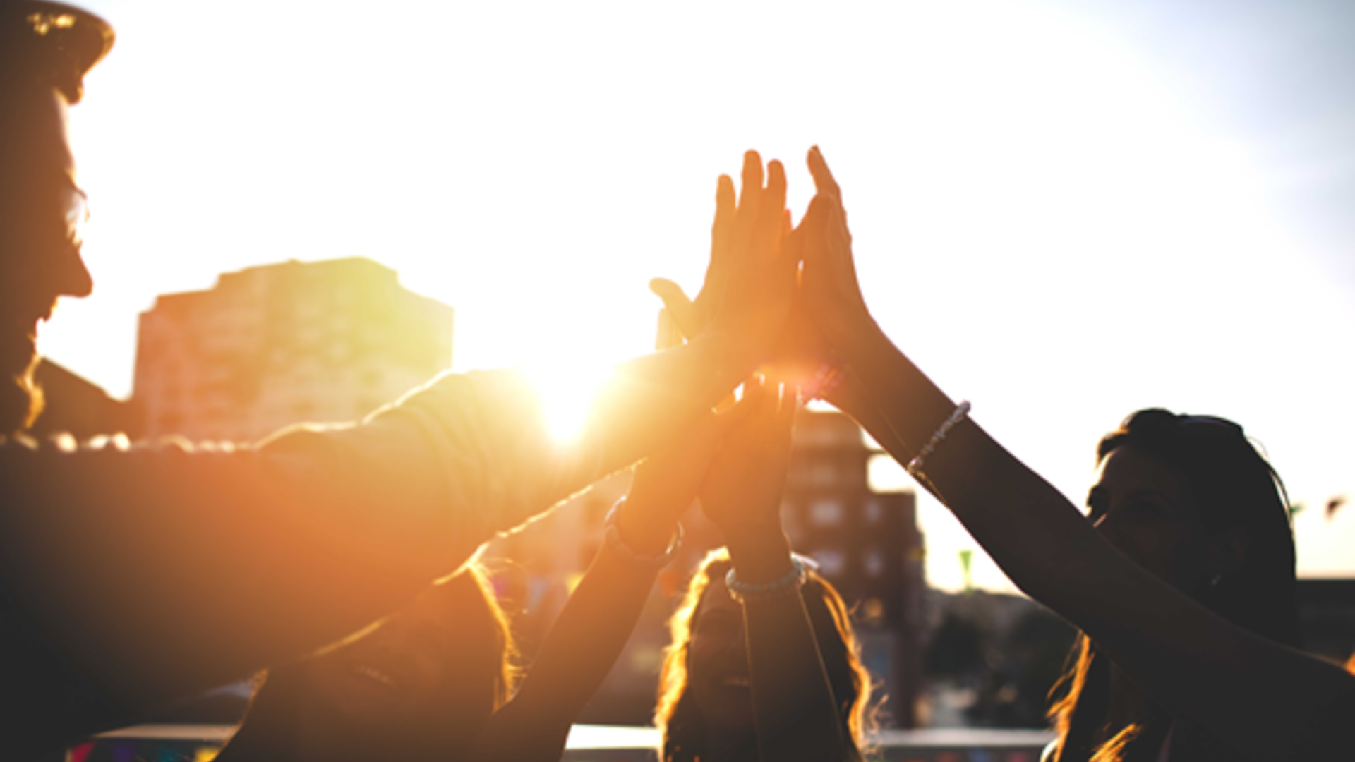 Mensen geven high five bij zonsondergang