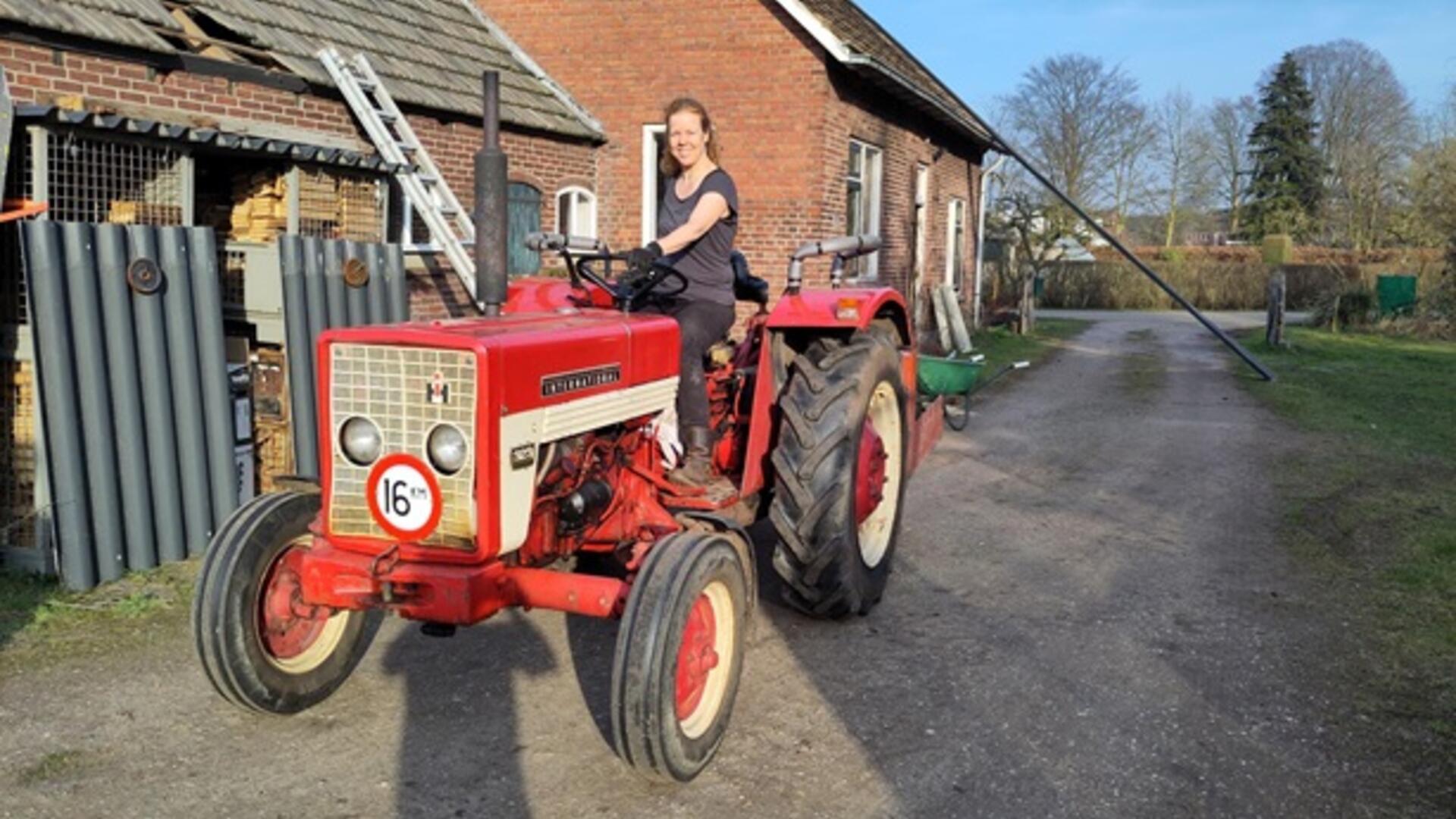 Anne op een oude rode trekker